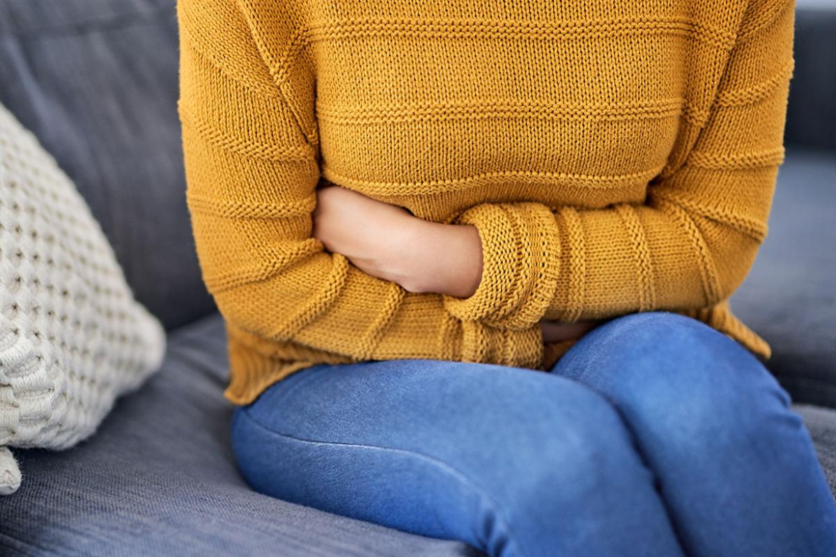 Sitting person clutching abdomen