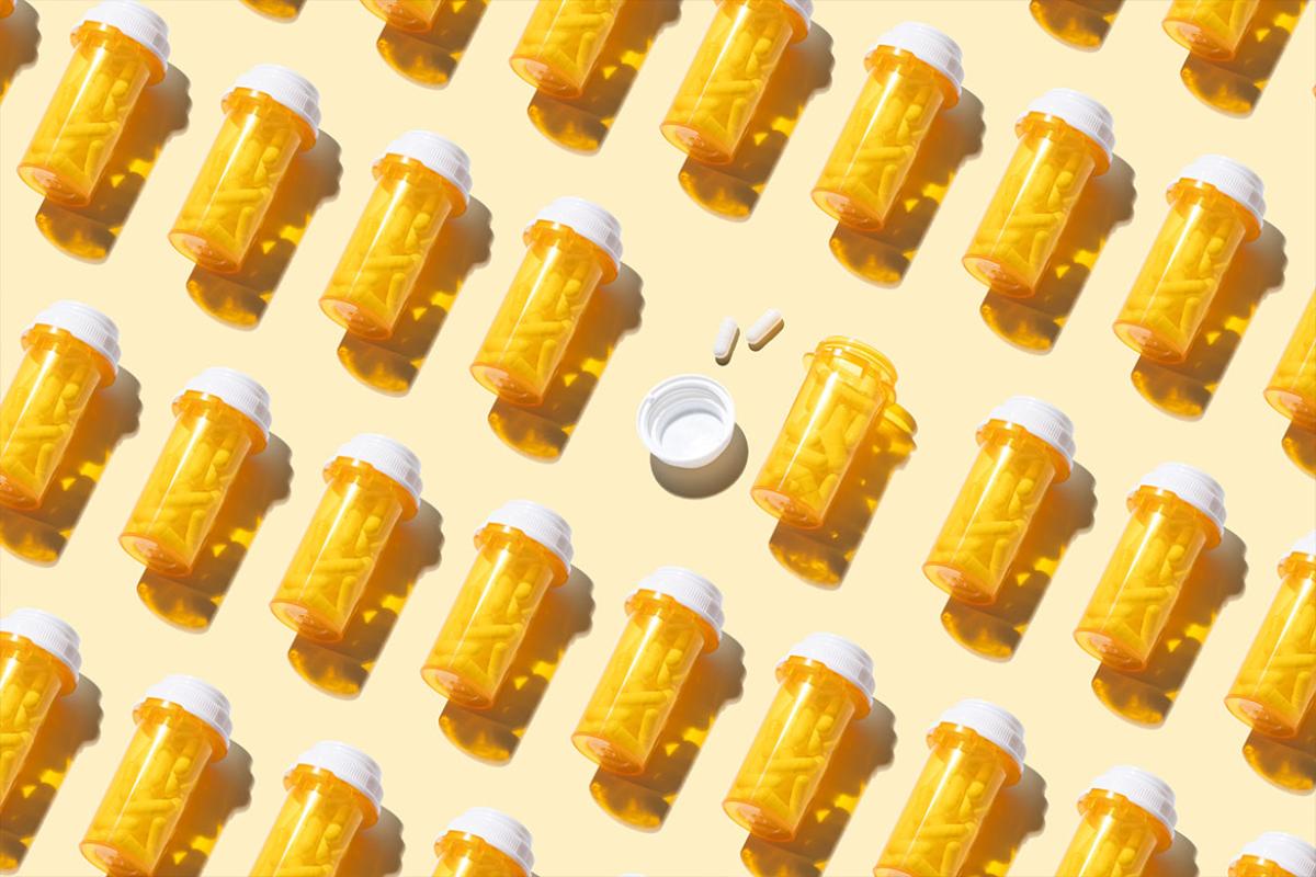 Opened prescription medicine bottle among many other sealed bottles