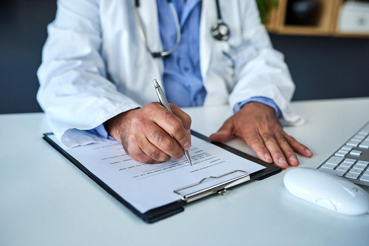 Doctor writing on a form