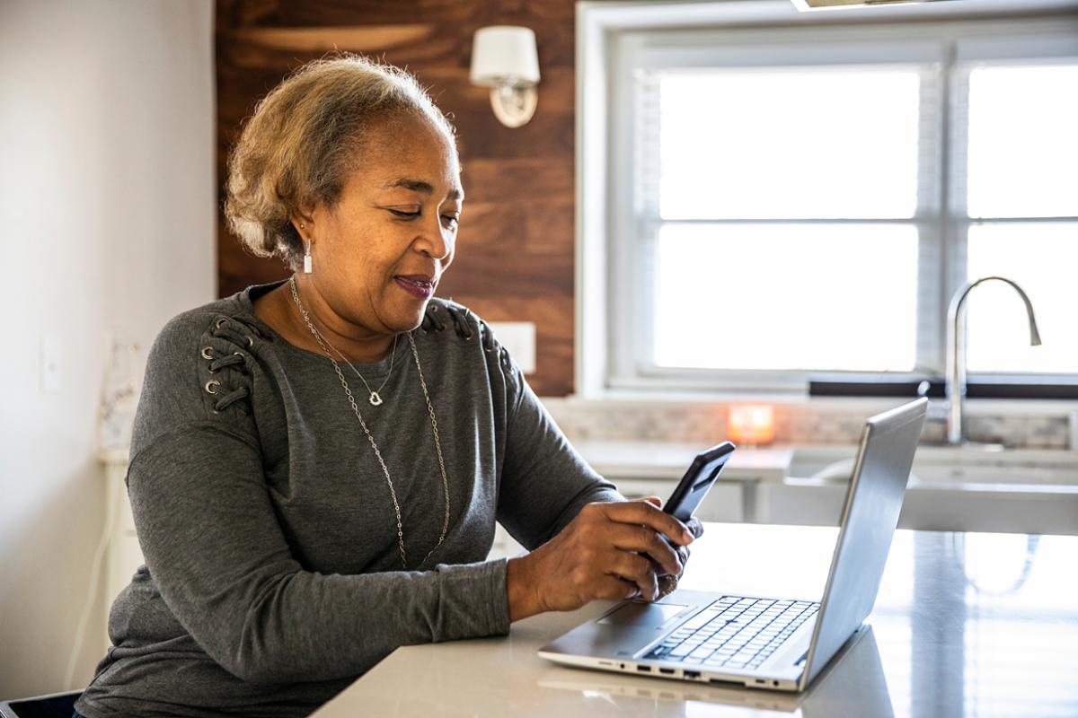 Smiling person working at a laptop
