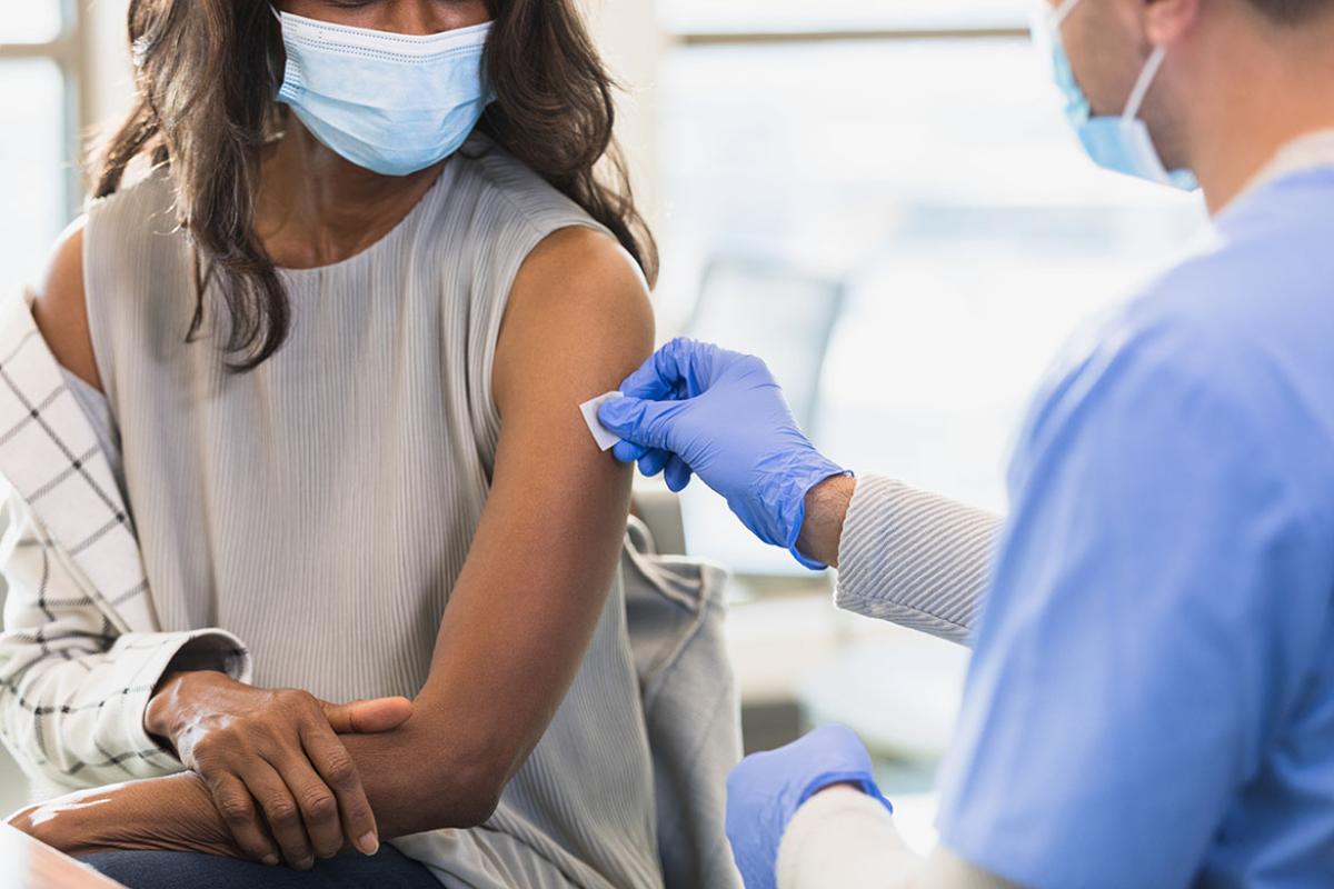 Health care worker prepping a patient's arm for an injection