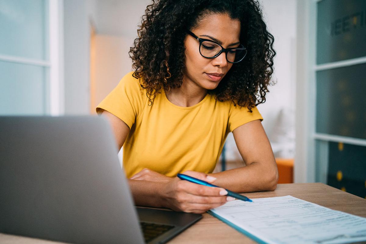 Person looking at a form, pen in hand