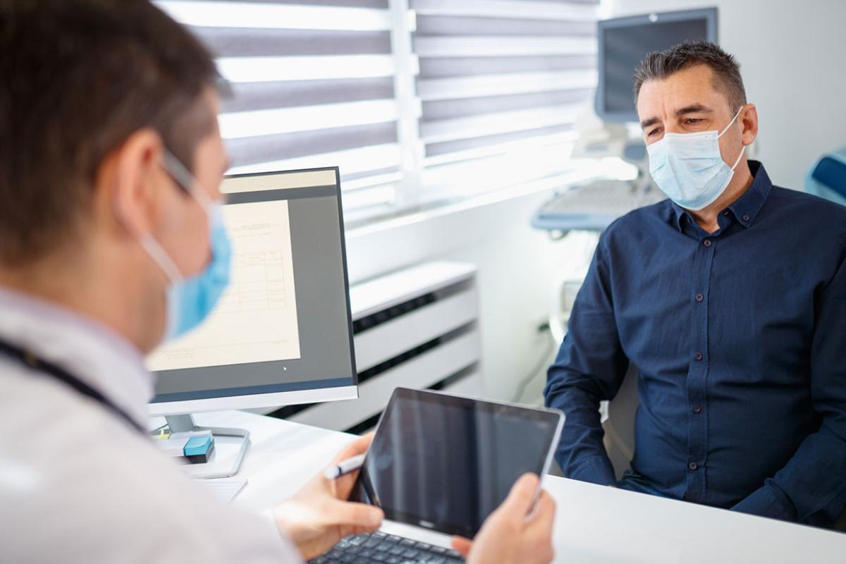 Physician sitting down with patient reviewing record