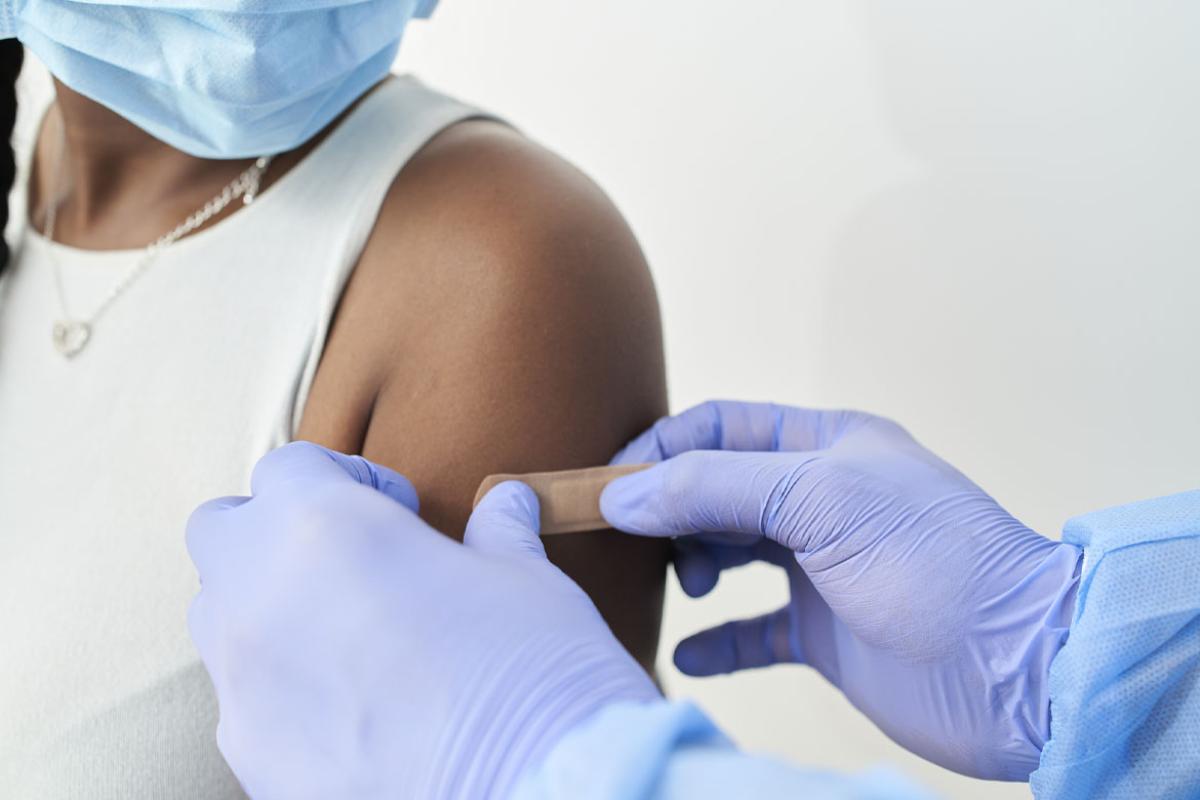 African-American woman receives a bandage on her arm after vaccination