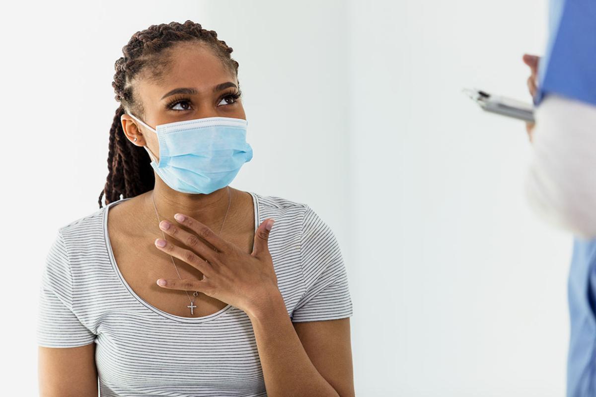 Patient with hand on chest speaking with health care worker