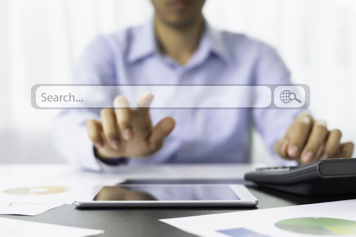 Hand reaching out to a virtual search bar