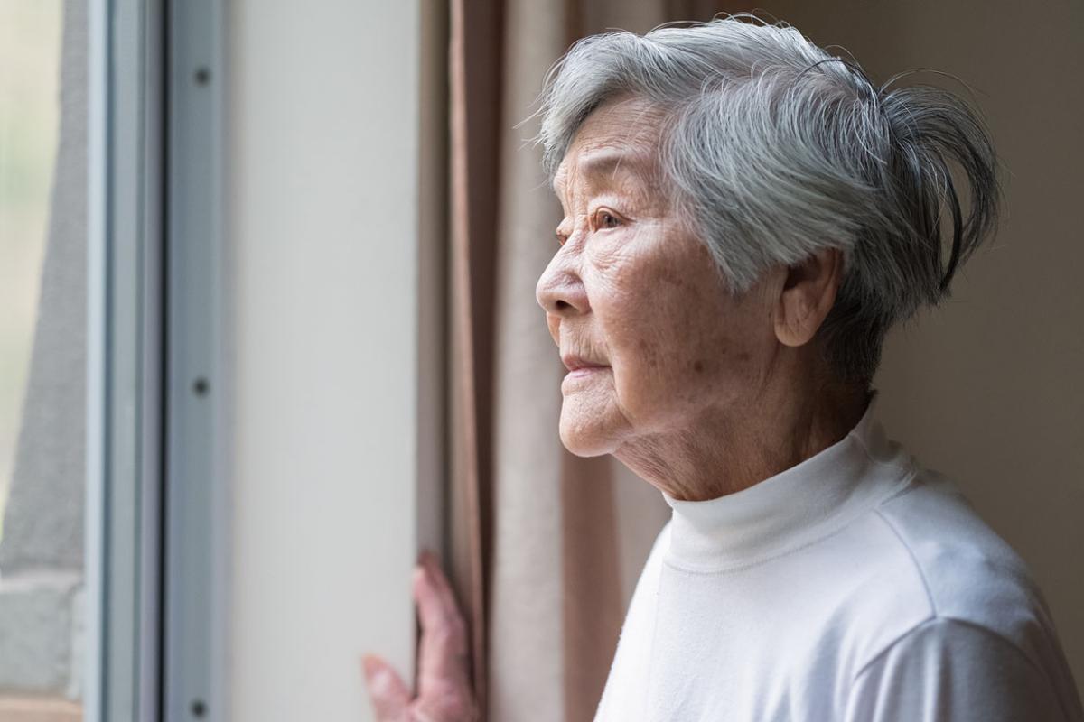 Senior person looking out a window
