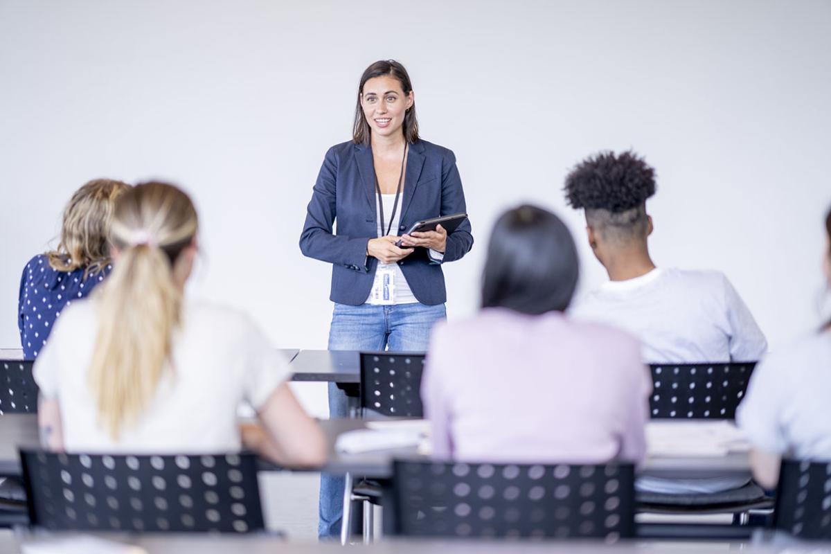 Professor stands at the front of a classroom 