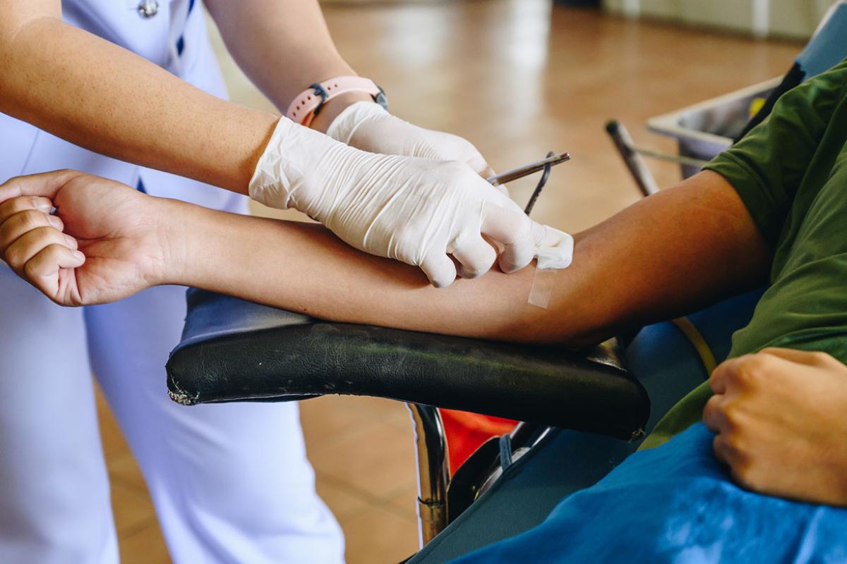 Health care worker applying adhesive bandage to a patient's arm