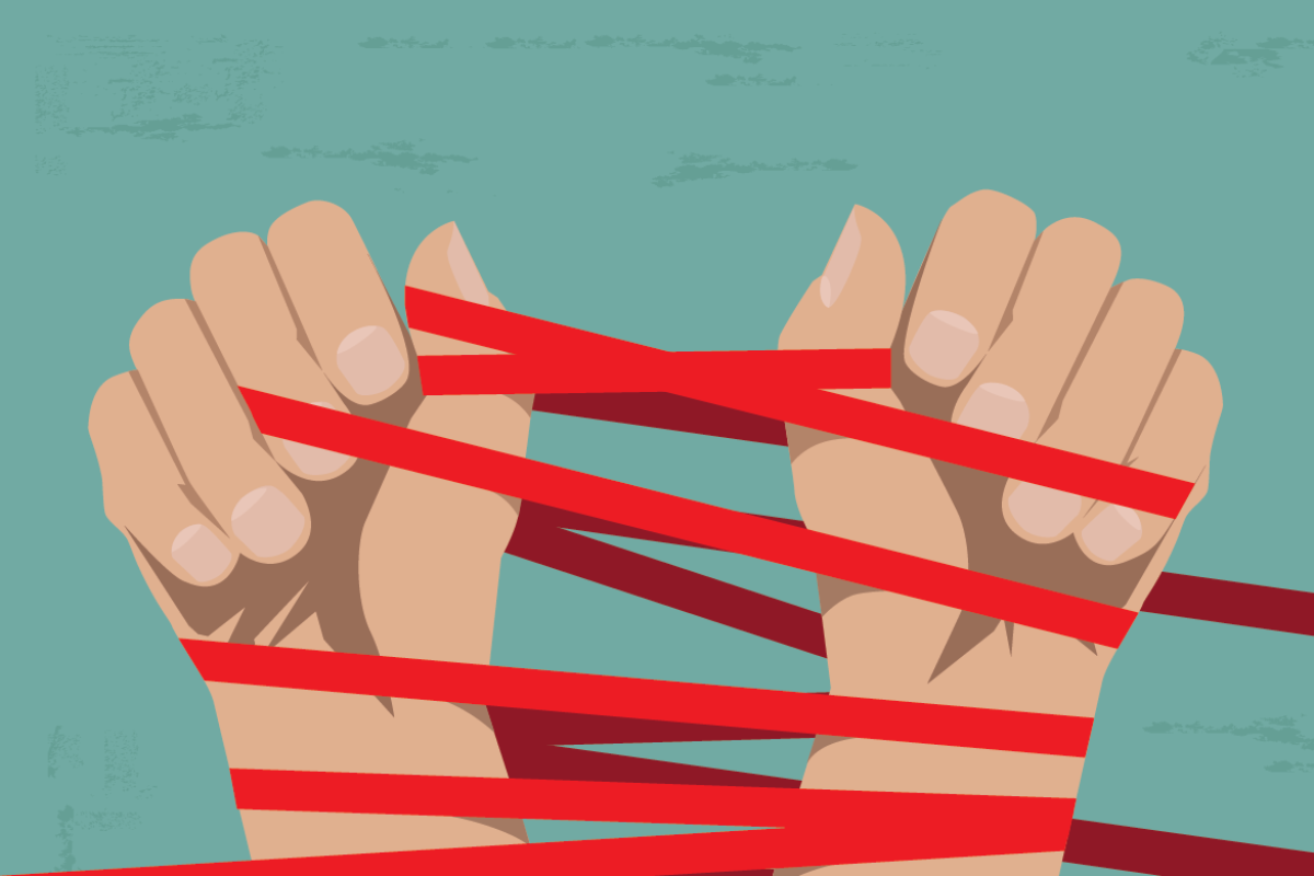 Pair of hands twined with red tape