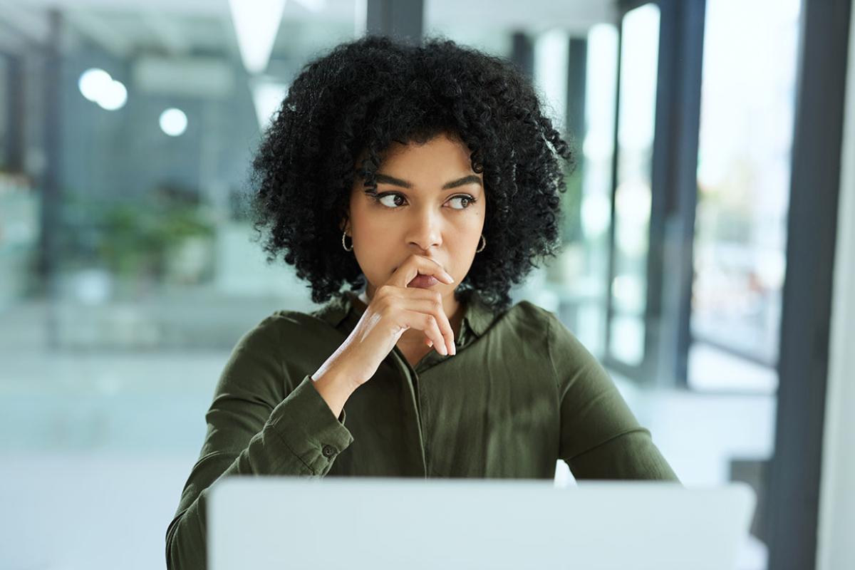 Female deep in thought sitting at a laptop