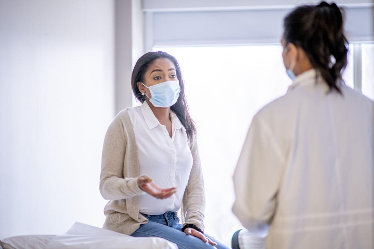 Patient speaking to physician in exam room