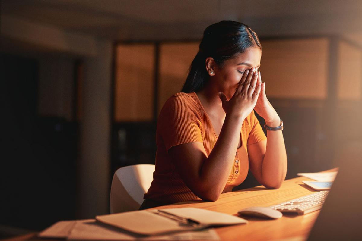 Person with eyes closed sitting at a desk