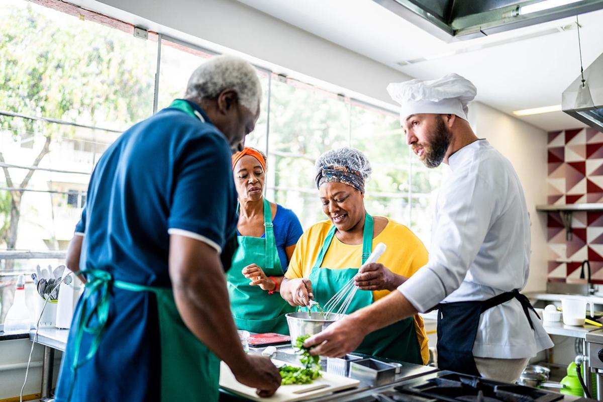 Chef teaching students during cooking class 