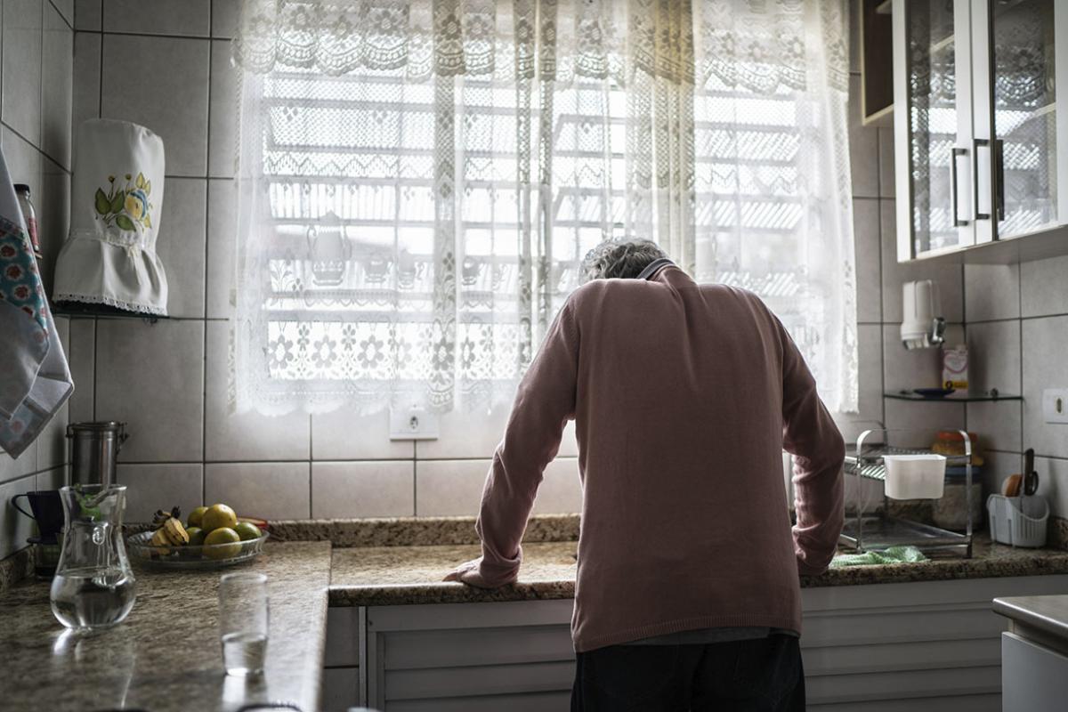 Slouched person with hands on kitchen counter