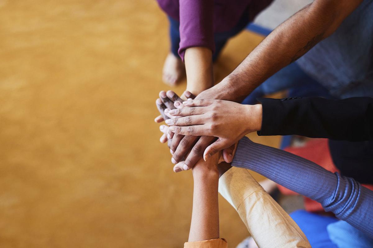 Group of people with hands stacked