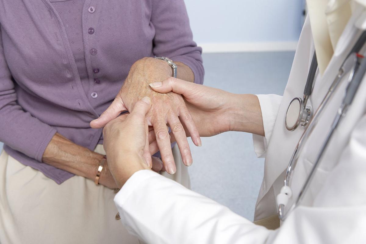 General practitioner examining patient and hand