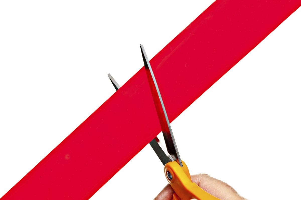 Scissors cutting red tape