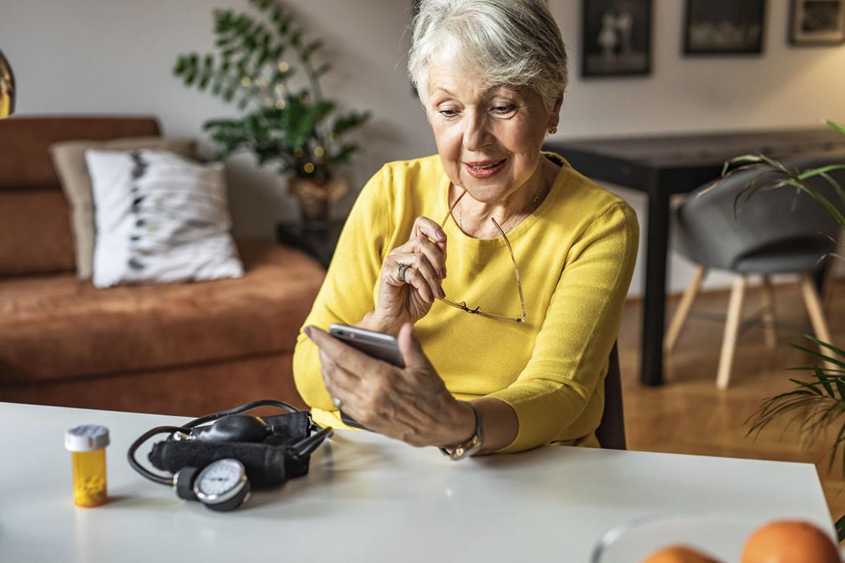 Senior person holding a pill bottle and looking at smart phone