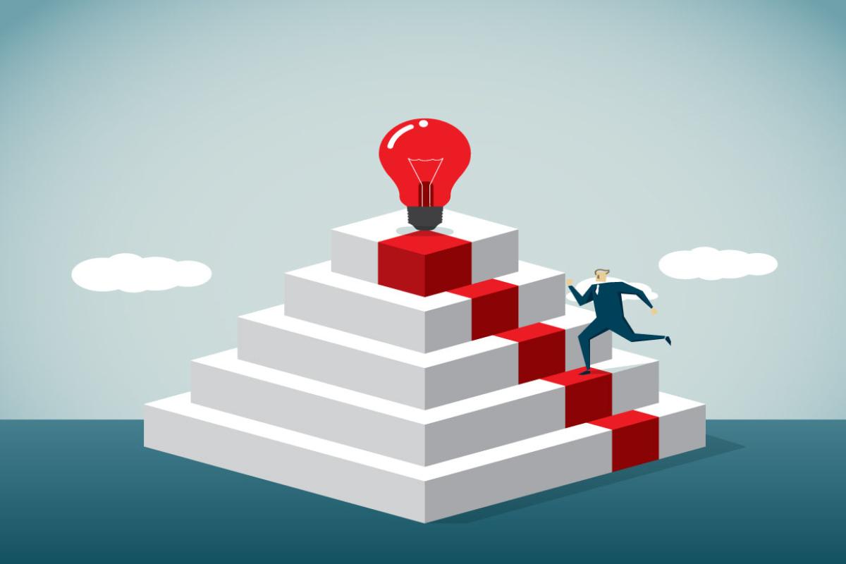 Figure ascending stairs toward a giant light bulb