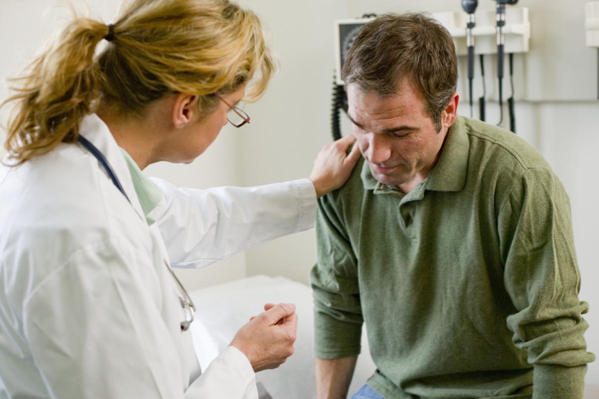 Physician with hand on patient's shoulder