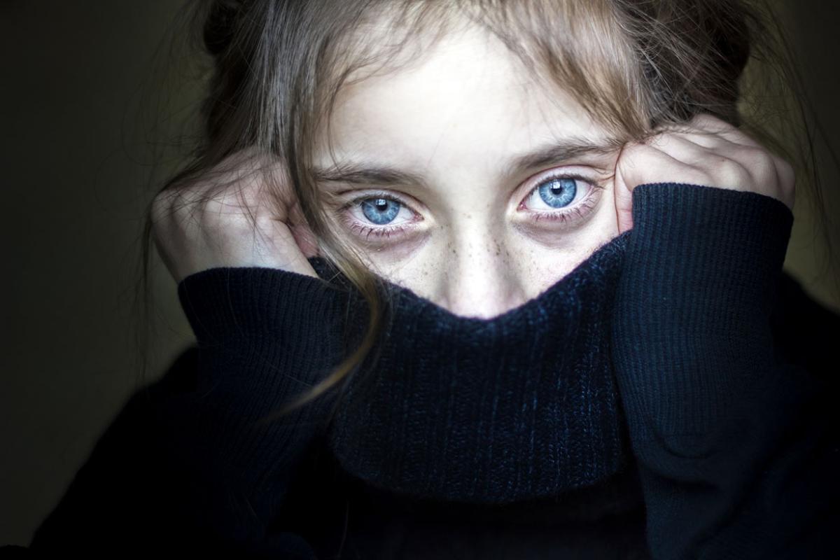 Young person hiding their face