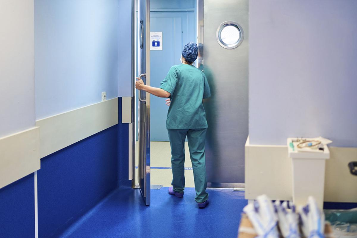 Health care worker opening a door in a hospital
