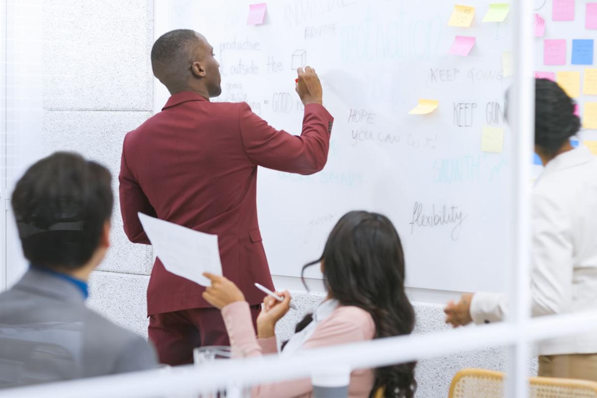 Person writing on a dry erase board