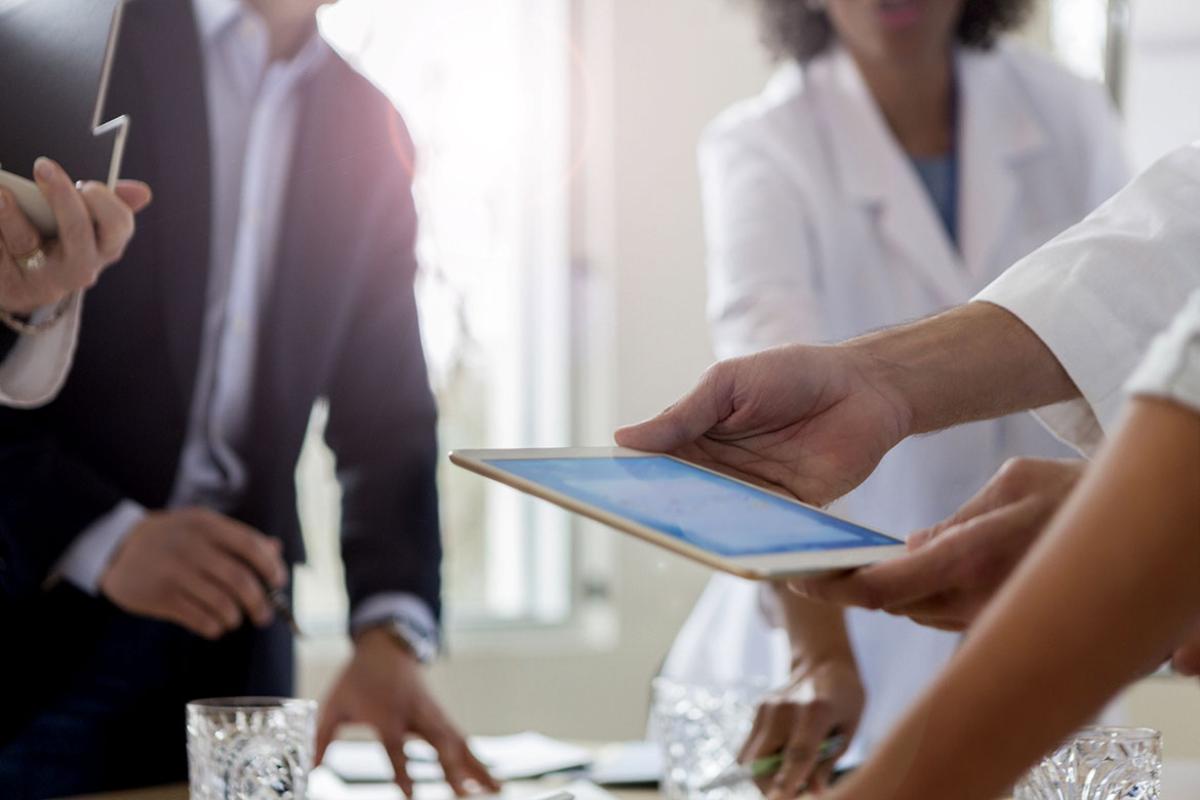 Group of people looking at a smart tablet