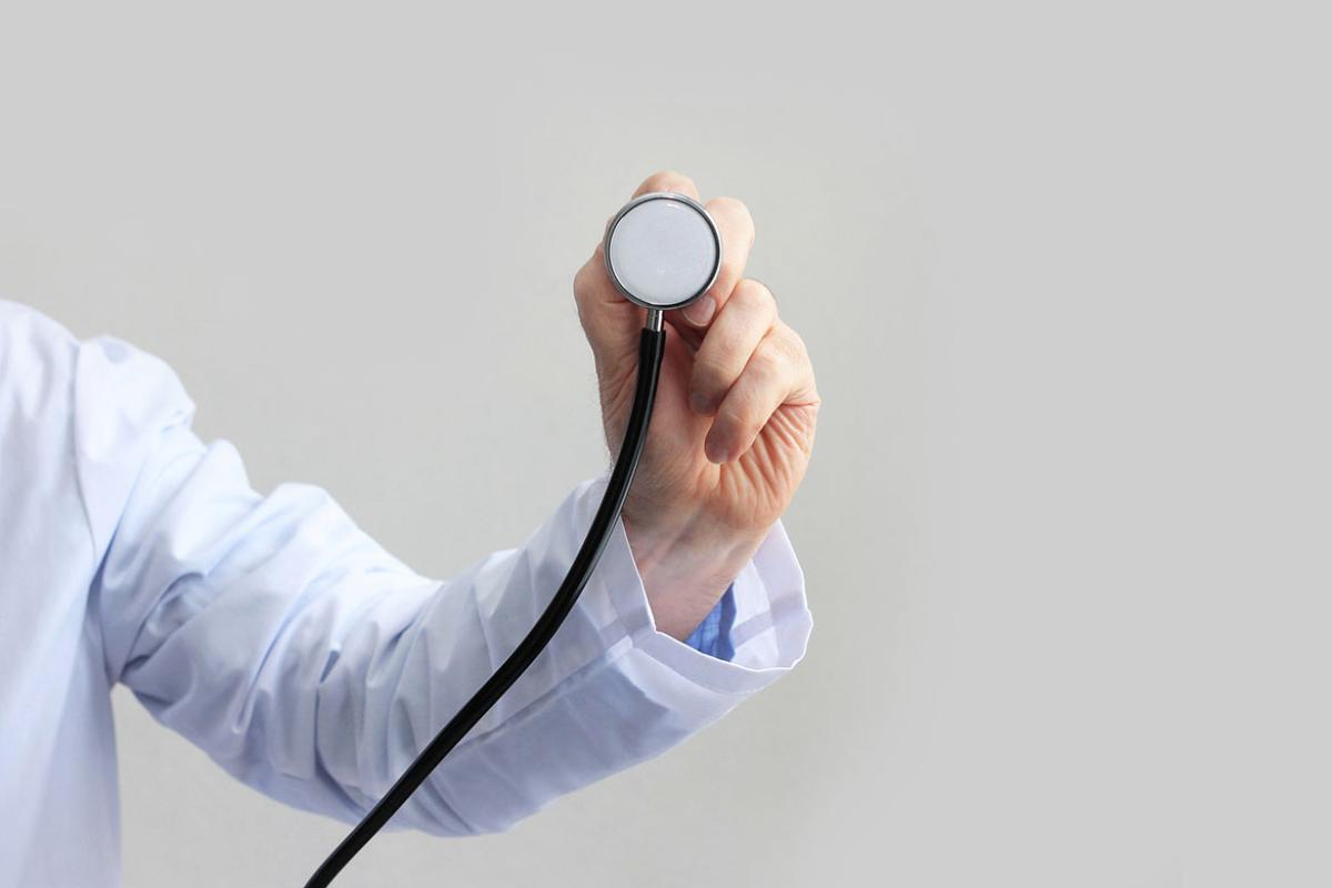 Male in lab coat holding a stethoscope