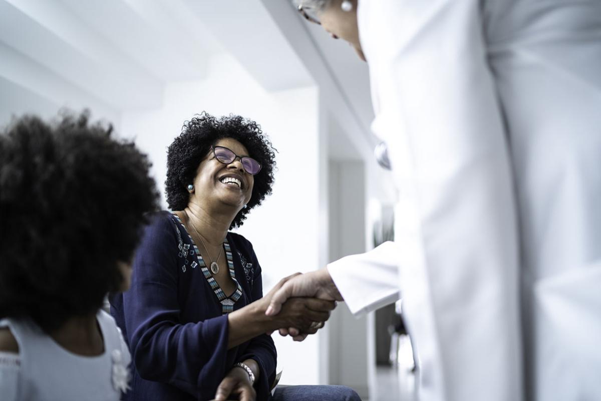 Family doctor welcoming parent and child