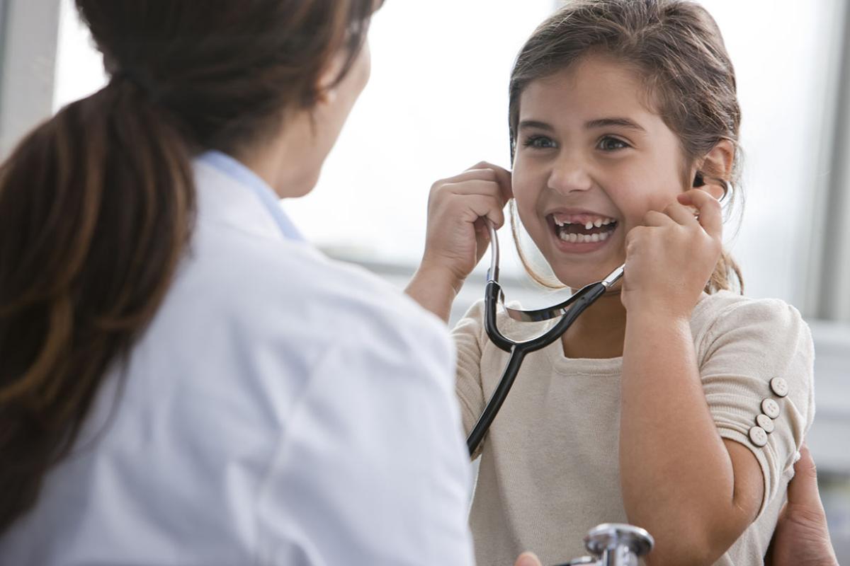 Smiling young patient using stethoscope 