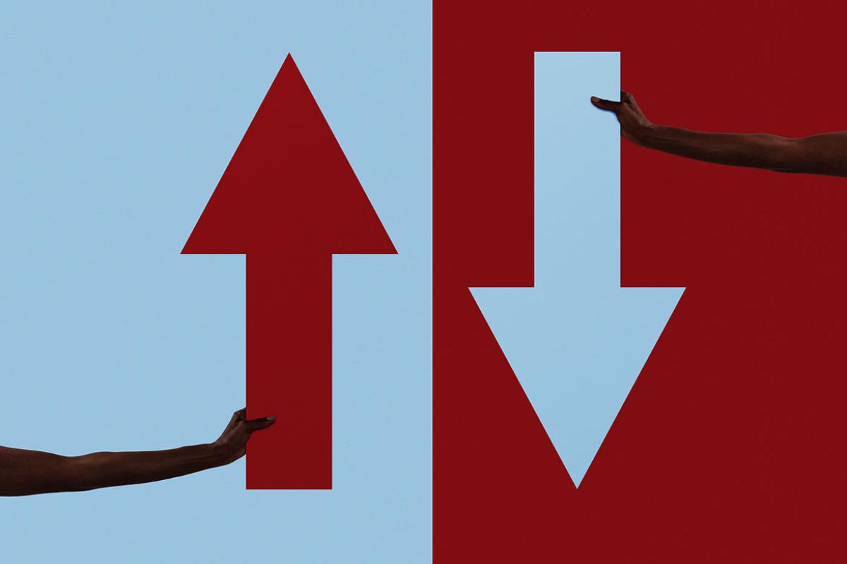 Human arms holding up and down arrows