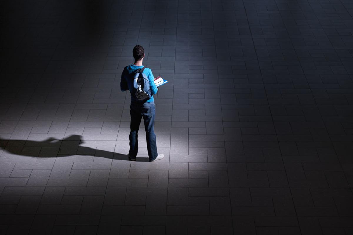 Student standing in a hallway solo