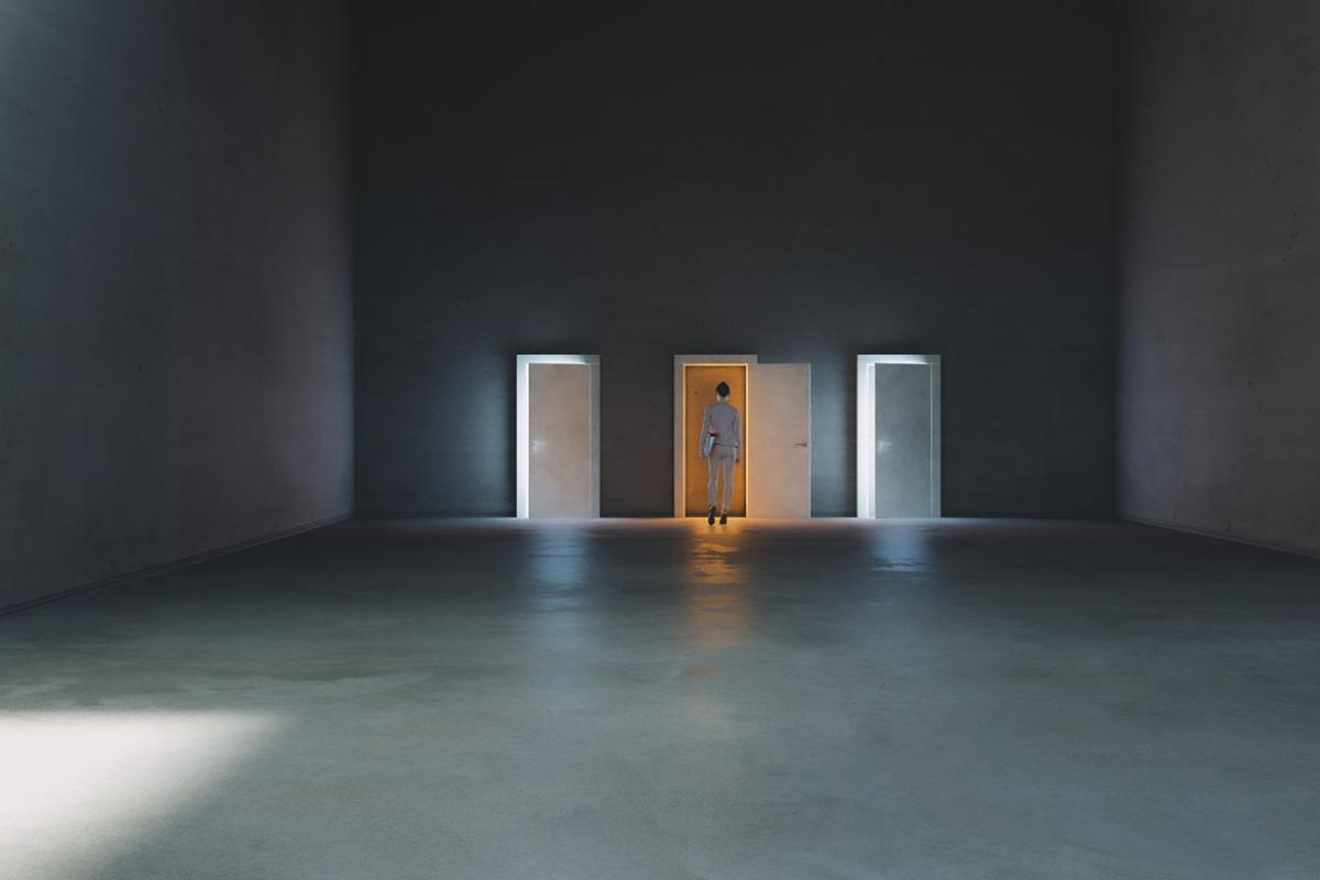 Person standing in front of three open doors