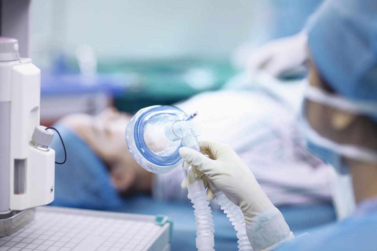 Nurse holding anesthesia mask in operating room