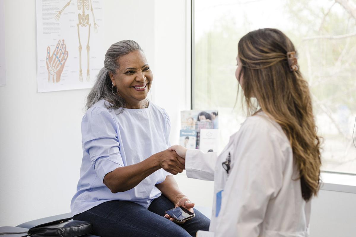 Doctor shakes hands with senior patient 