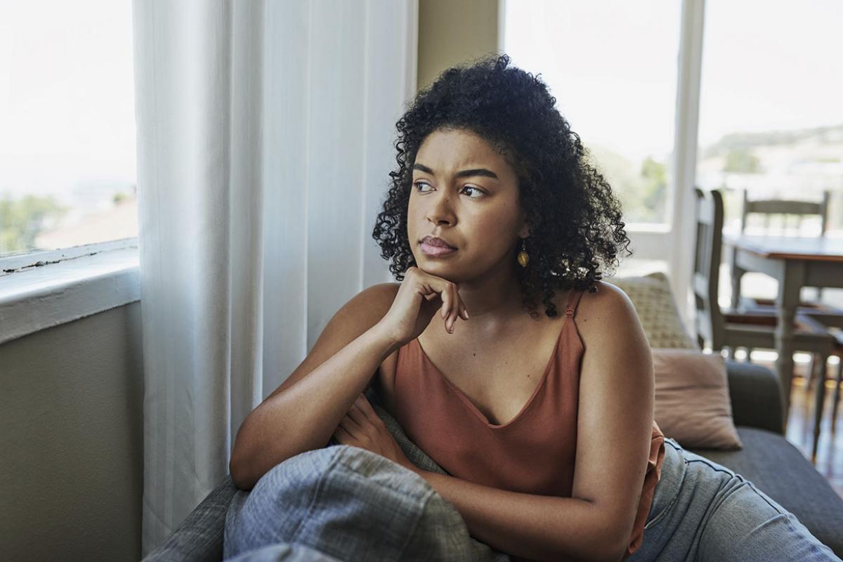 Woman sitting on couch looking out a window