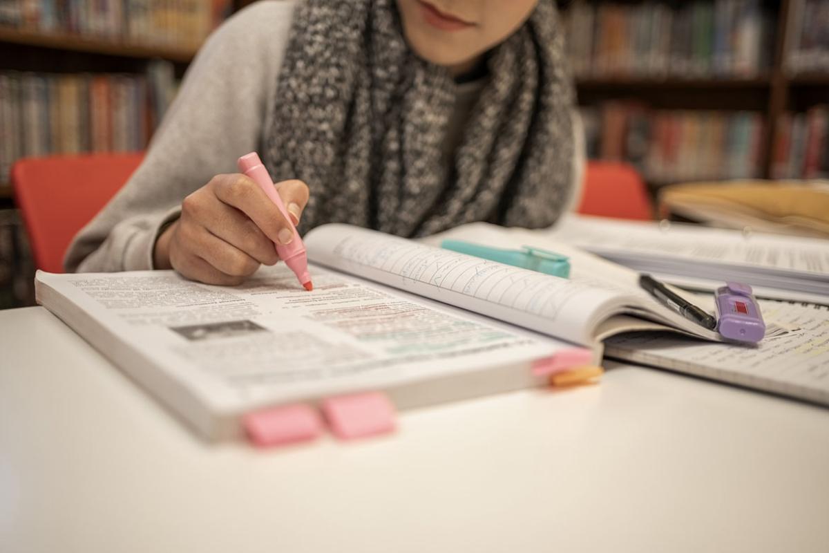 Student highlighting text in a book