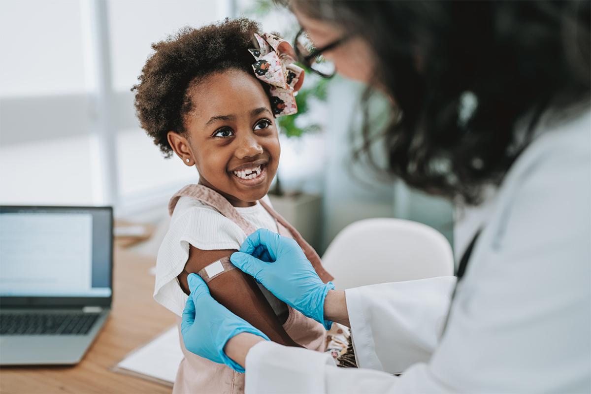 Smiling little girl receiving a vaccination
