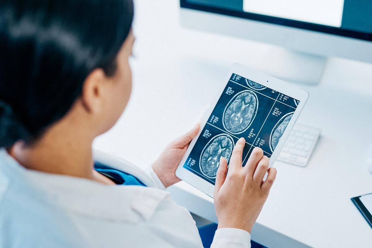 Doctor analyzing brain scans on a digital tablet