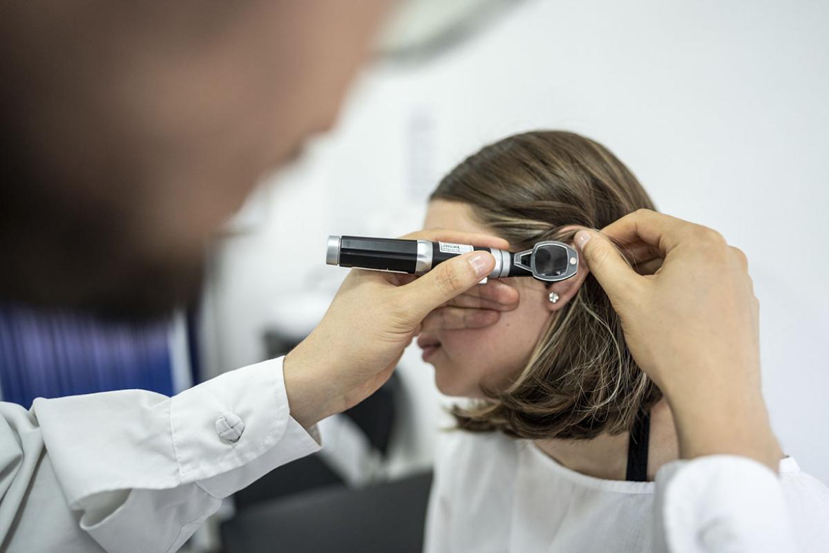 Doctor/otolaryngologist using an otoscope in a patient's ear 