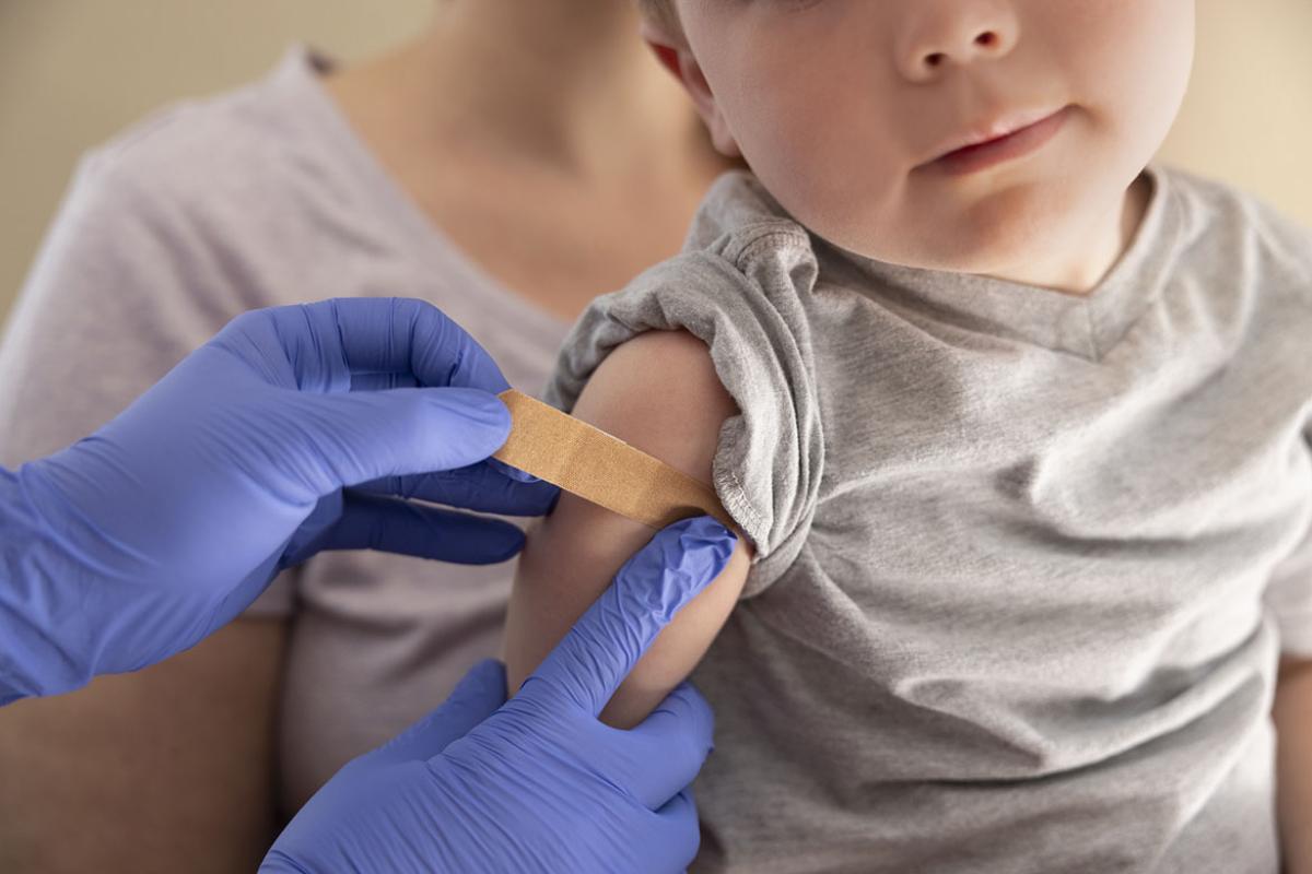  Hands applying a bandage to a young child's arm