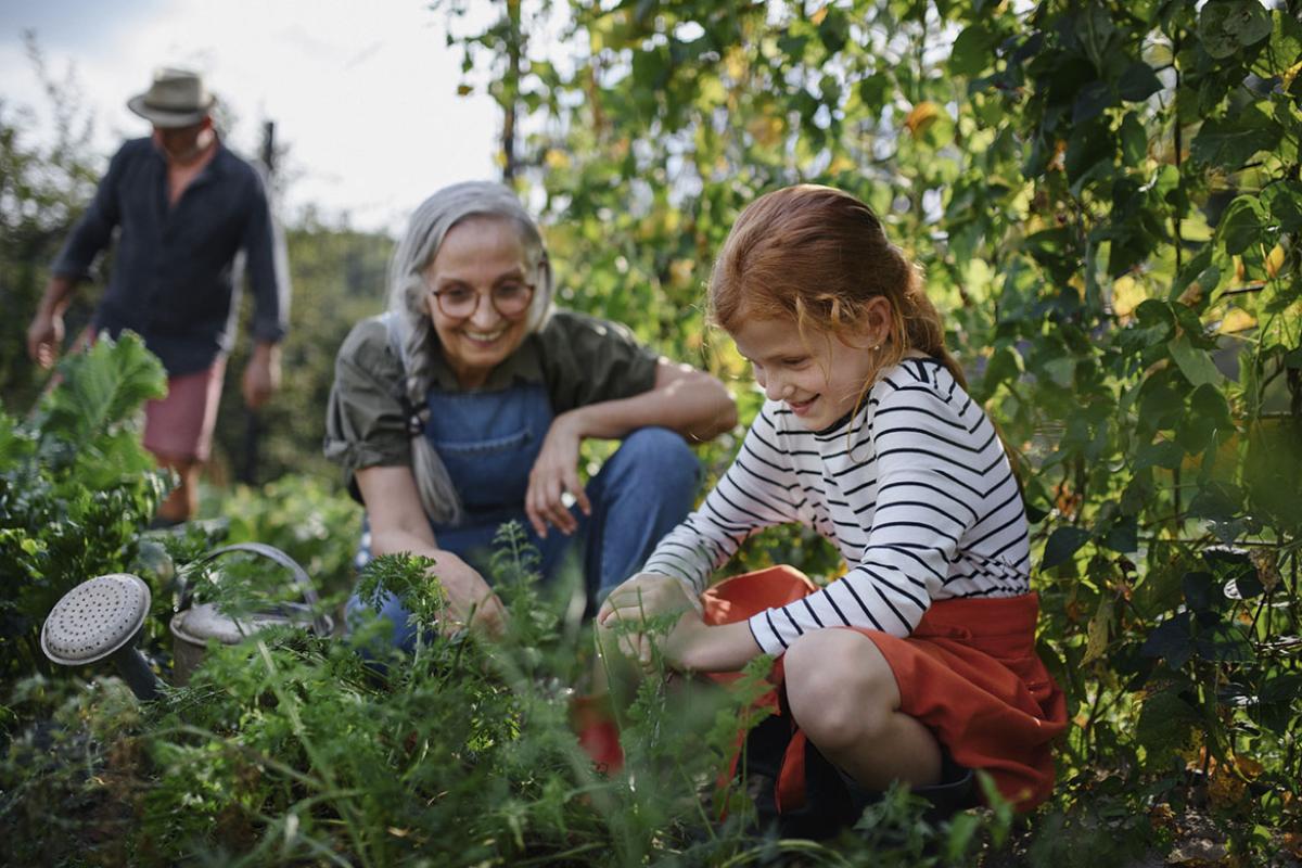 Smiling adult and young child in a garden