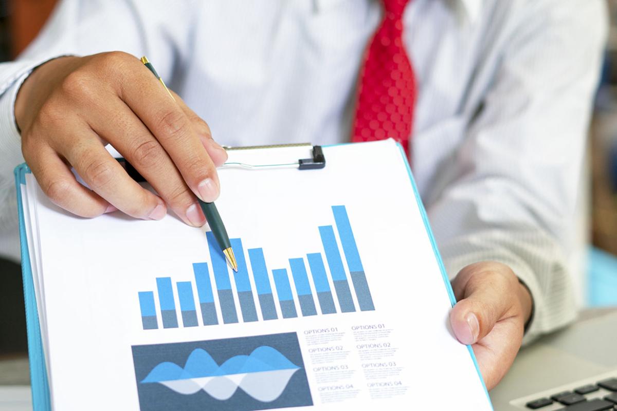 Person using a pen to point to a bar on a bar chart