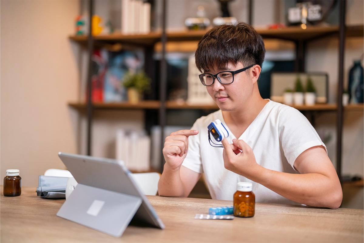 Person pointing to oximeter while on a telehealth appointment