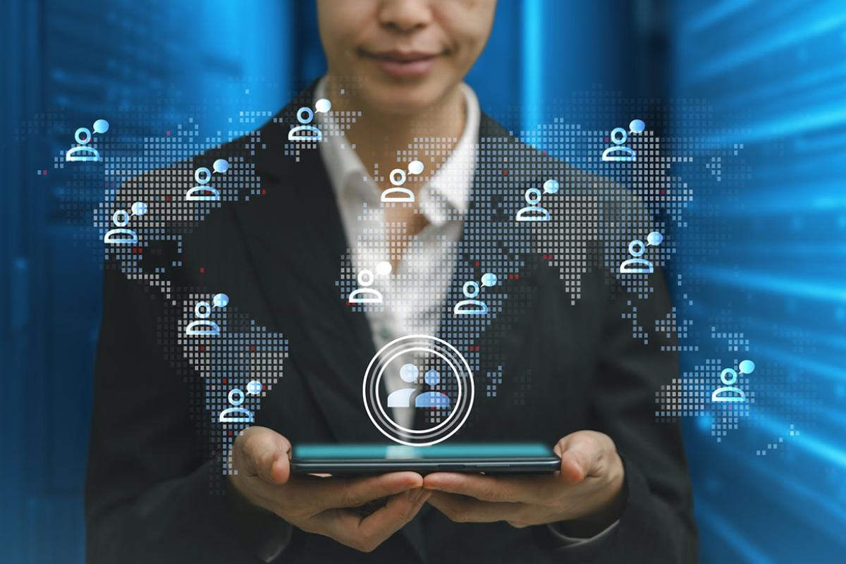 Businessperson holding tablet with network technology icons surrounding the screen