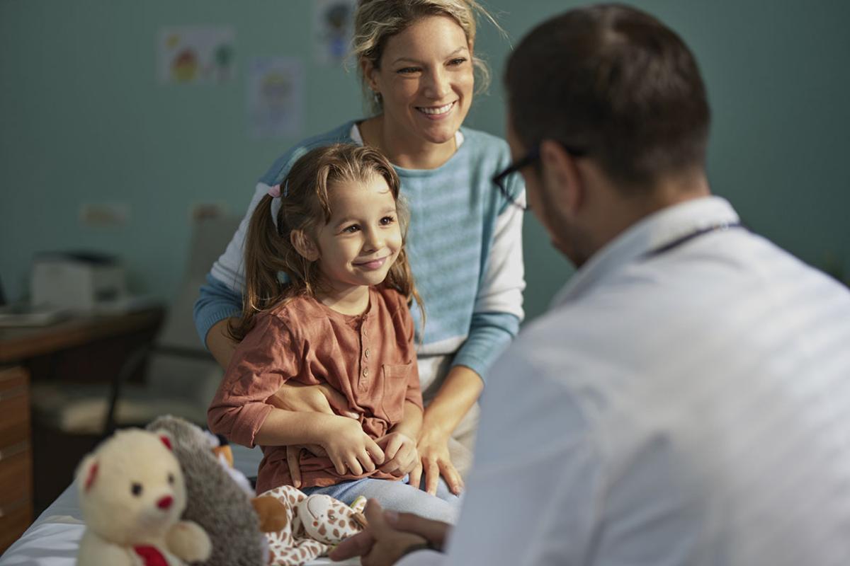 Smiling parent and young child at a doctor's appointment