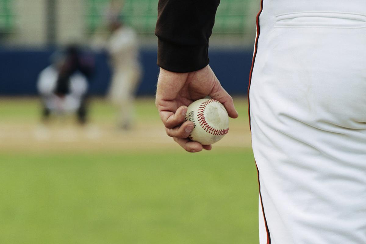 Baseball pitcher on mound holding baseball 