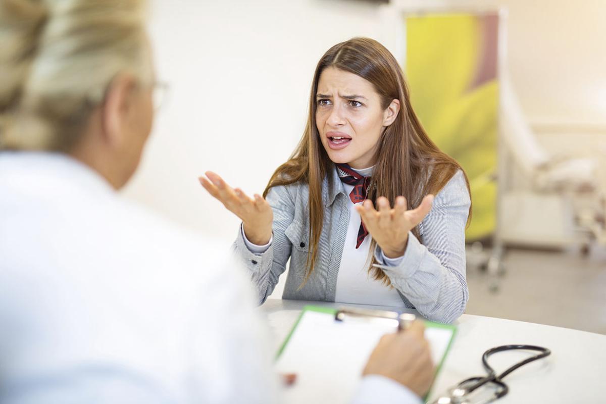 Perturbed patient holds up hands during an appointment